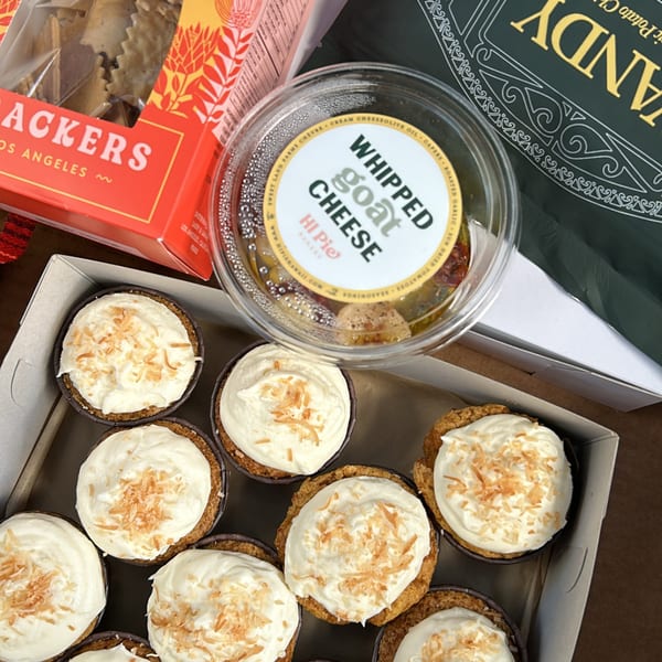 A box of HI Pie Bakery + Cafe mini pies with whipped topping and toasted coconut flakes.